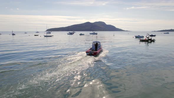 A Small Passenger Ferry Departing a Port and Moorings