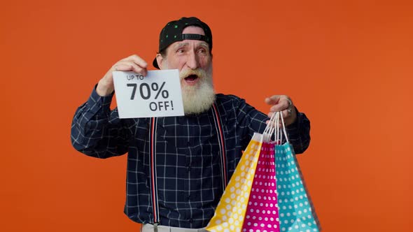 Senior Bearded Man Showing Shopping Bags and Up To 70 Percent Off Inscriptions Banner Black Friday