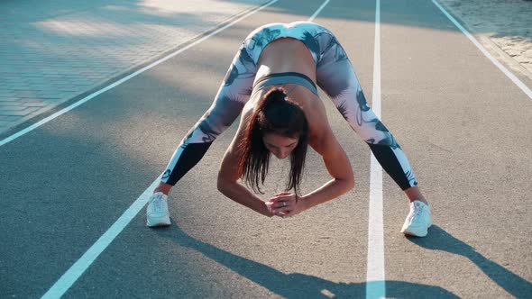 Attractive Young Sportswoman is Getting Ready Before Running Marathon While Doing Stretching His