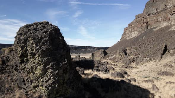Skimming ancient basalt volcanic columns on the canyon floor of Dry Falls State Park, aerial