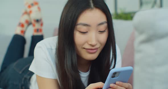 Close Up Young Asian Woman Resting on Cozy Sofa Web Surfing Interesting Information in Internet