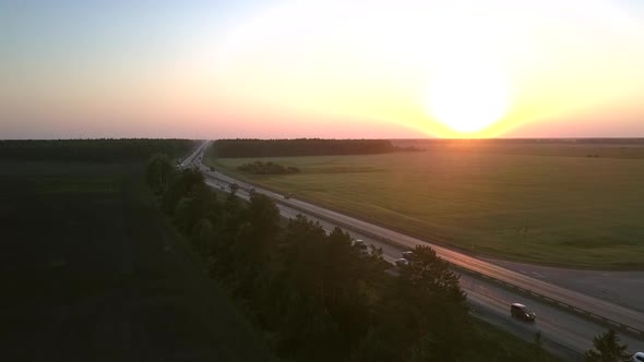 Cars Drives Along Road in Rural Land at Sunset Aerial View