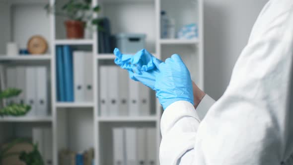 Medic Nurse Puts On Blue Medical Gloves, Doctor Puts On Protective Latex Gloves For Examining