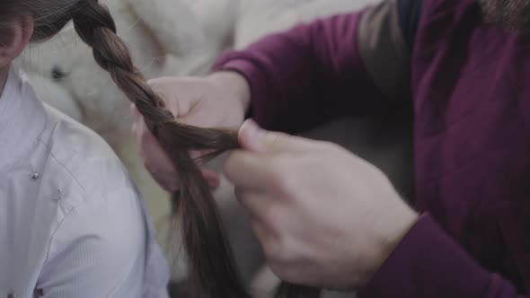 Male Caucasian Hands Braiding Pigtails. Father Doing Hairstyle for His Brunette Daughter. Fatherhood