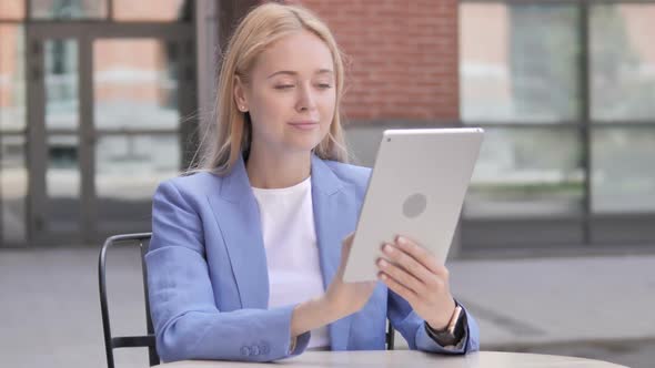 Young Businesswoman Sitting Outdoor and Using Tablet