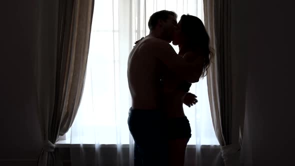 Couple Kissing Near a Window.