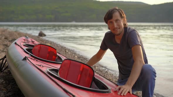 Young Man Inflates His Kayak and Prepares It for Paddling in a Lake or Sea. Slowmotion Shot