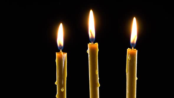 Three burning wax candles with a warm yellow flame. Mock up template.