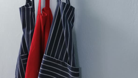 Various aprons hanging on hook 4k