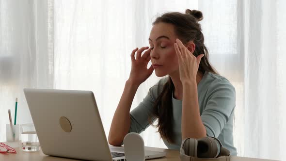 Exhausted Female Freelancer Using Laptop at Home