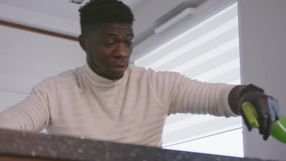 Happy Black Man Dancing and Sanitizing His Furniture. Low Angle Shot