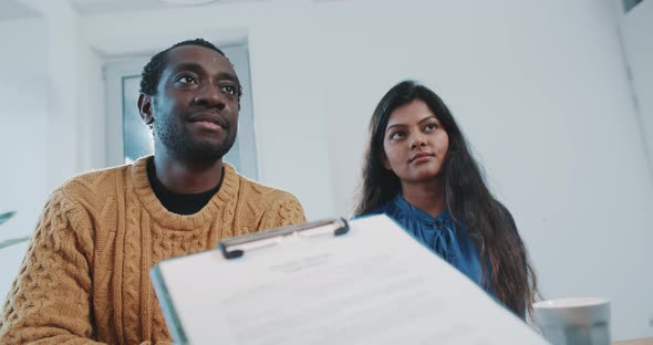 Couple discussing house rental contract with sales agent