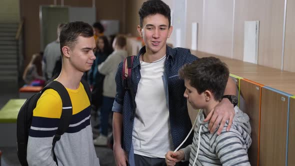 Bullies Mocking Student Standing By School Locker