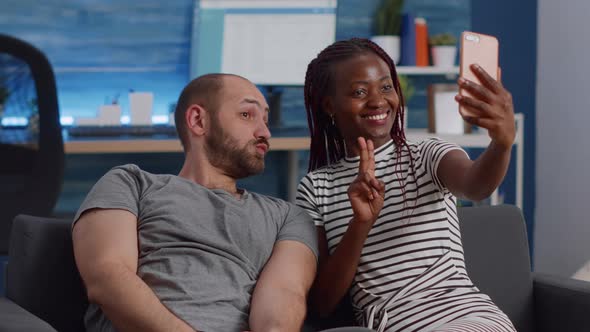 Cheerful Interracial Couple Taking Pictures with Smartphone