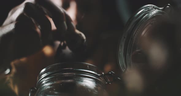 A man placing the wild mushrooms in the glass container