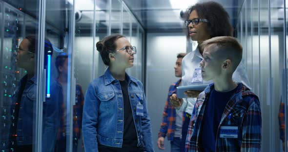 Female Technician Showing Around Children in Server Park