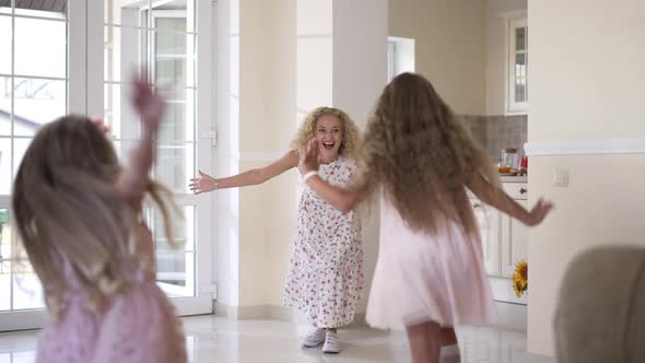 Wide Shot Excited Woman Rejoicing As Joyful Girls Running Hugging Parent in Slow Motion