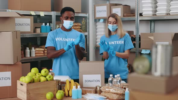 Two Volunteers Wearing Face Masks and Gloves at Food Bank