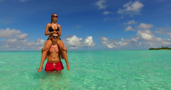 Beautiful boy and girl on honeymoon vacation live the dream on beach on white sand background 4K