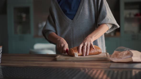 Woman cuts bread on board