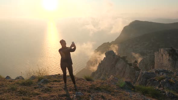 Beautiful Woman Having Video Chat Using Smartphone Outdoors Against Beautiful Dramatic Sunset Above