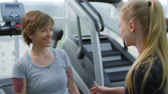 Two Cheerful Women Talking in Gym
