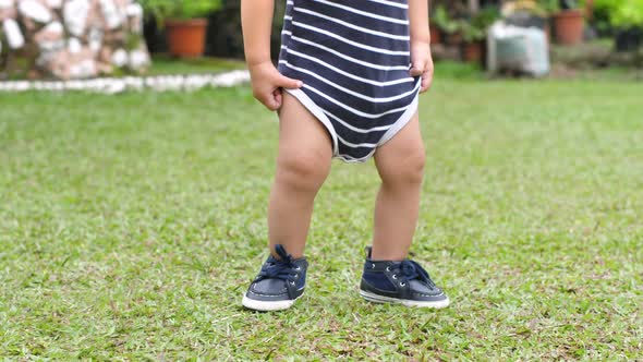 Curious and Happy Little Baby in Shoes Learning to Walk at the Park with Mother