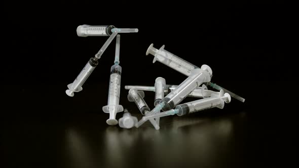 Syringes bouncing on black background, Ultra Slow Motion