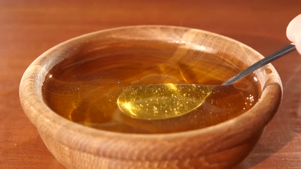 Taking Honey By Using Spoon in Wooden Bowl, Flowing Down