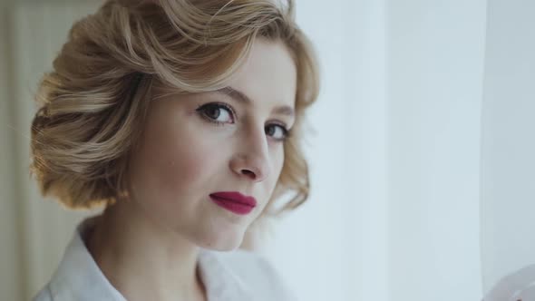 Portrait of Happy Lady Smiling at Camera at Light Window in Room