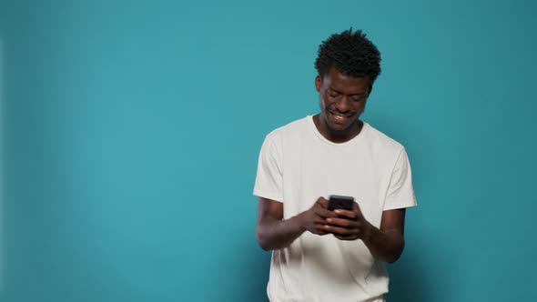 Casual Person Looking at Smartphone and Dancing in Studio