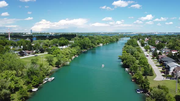 Aerial flyover Welland creek in Canada near Niagara Falls during beautiful sunny day withing boats a