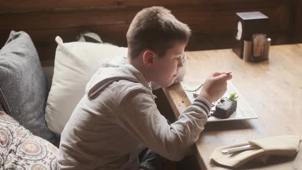 Appetite and enjoyment of food. Funny baby boy eating brownie. Child eats with appetite