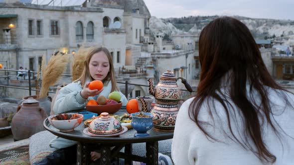 Mother and Daughter Eating Fruits on Terrace in Cappadocia