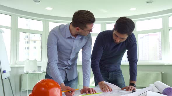 Two Architects Work on the Project at the Office