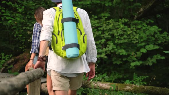Young Tourists are Hiking in Green Forest