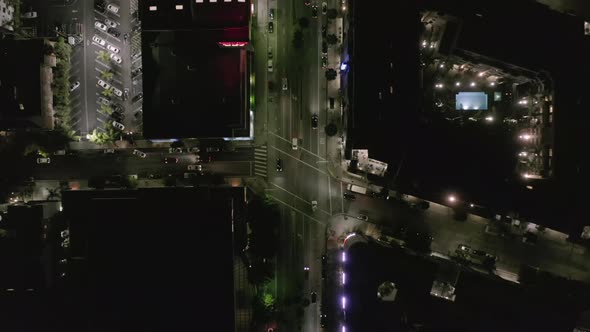 AERIAL: Overhead View on Wilshire Boulevard Street in Hollywood Los Angeles at Night with Glowing