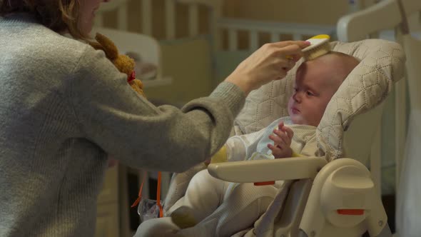 Mother Combing A Baby