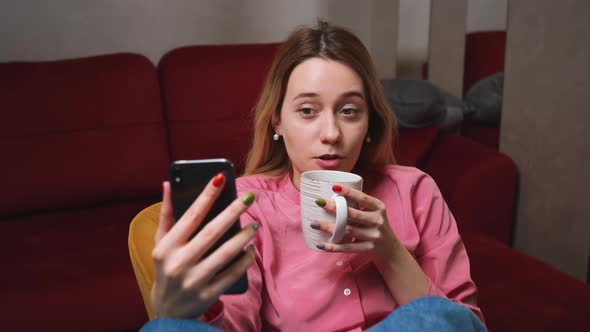 Relaxed Woman Making a Video Call Smiling and Talking with Her Friend and Family at Home Drinking