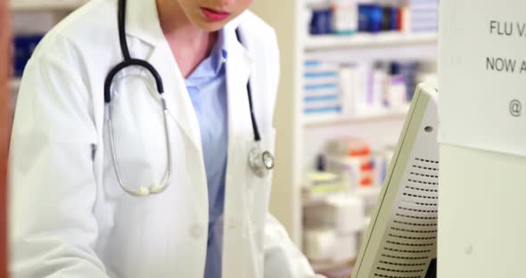 Pharmacist making prescription record on computer