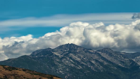 Time lapse of beautiful bellowing cumulus clouds forming above rugged mountain peaks in this stunnin