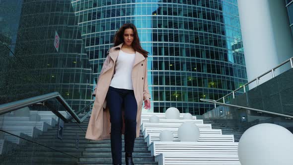 Slim Girl with Long Hair Quickly Descends Stairs