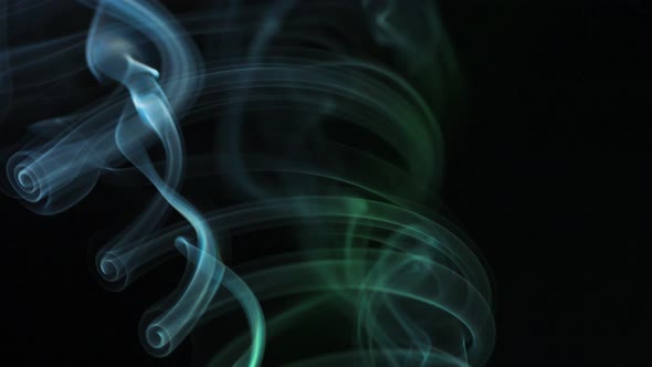 Abstract Colored Smoke Rises Up in Beautiful Swirls on a Black Background