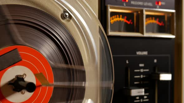 Vintage Reel to Reel tape recorder playing music close up of reel