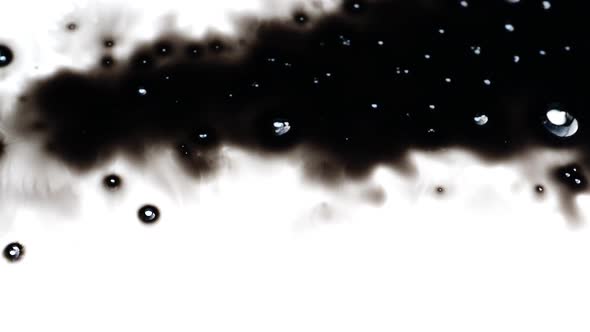 Black ink being dropped over white surface