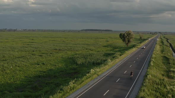 A Cyclist is Passing Quickly Along the Highway