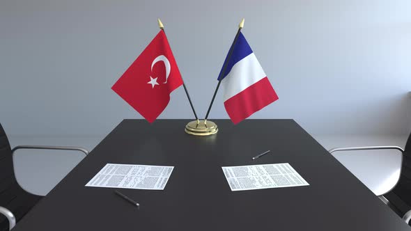 Flags of Turkey and France and Papers on the Table