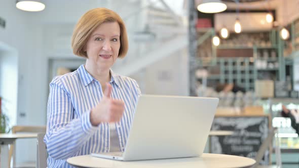 Thumbs Up By Creative Old Woman Using Laptop in Cafe 