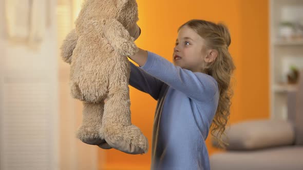 Cute Little Girl Looking at Teddy Bear and Hugging It, Favorite Toy, Childhood