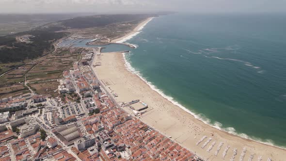Long white sand beach and resort town of Nazare, Portugal. Establisher shot